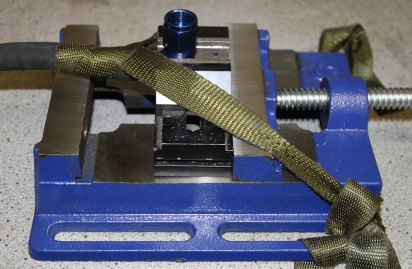Strap hose to drill press vice